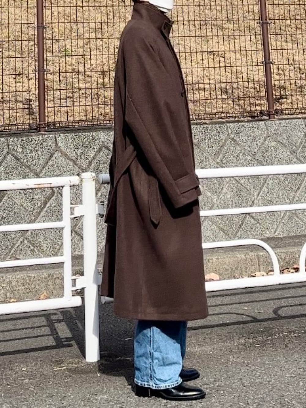 ブラック系のデニムパンツ、ブラウン系のその他アウター、ブラック系のニット/セーターを着用したメンズの冬コーディネートの4枚目の写真