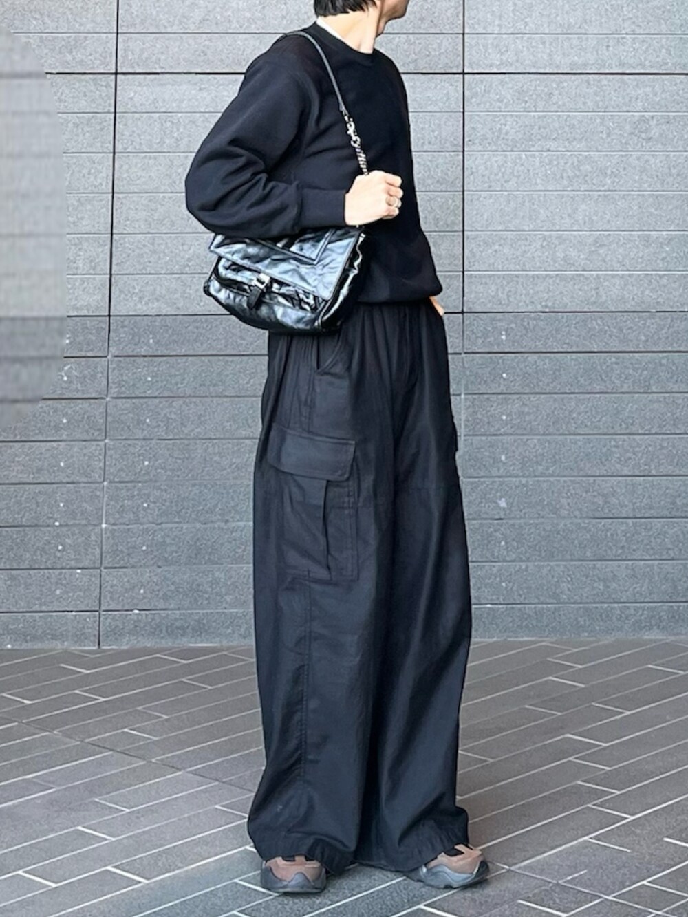 ブラック系のカーゴパンツ、グレー系のスウェット、ブラウン系のスニーカーを着用したメンズの春コーディネートの3枚目の写真