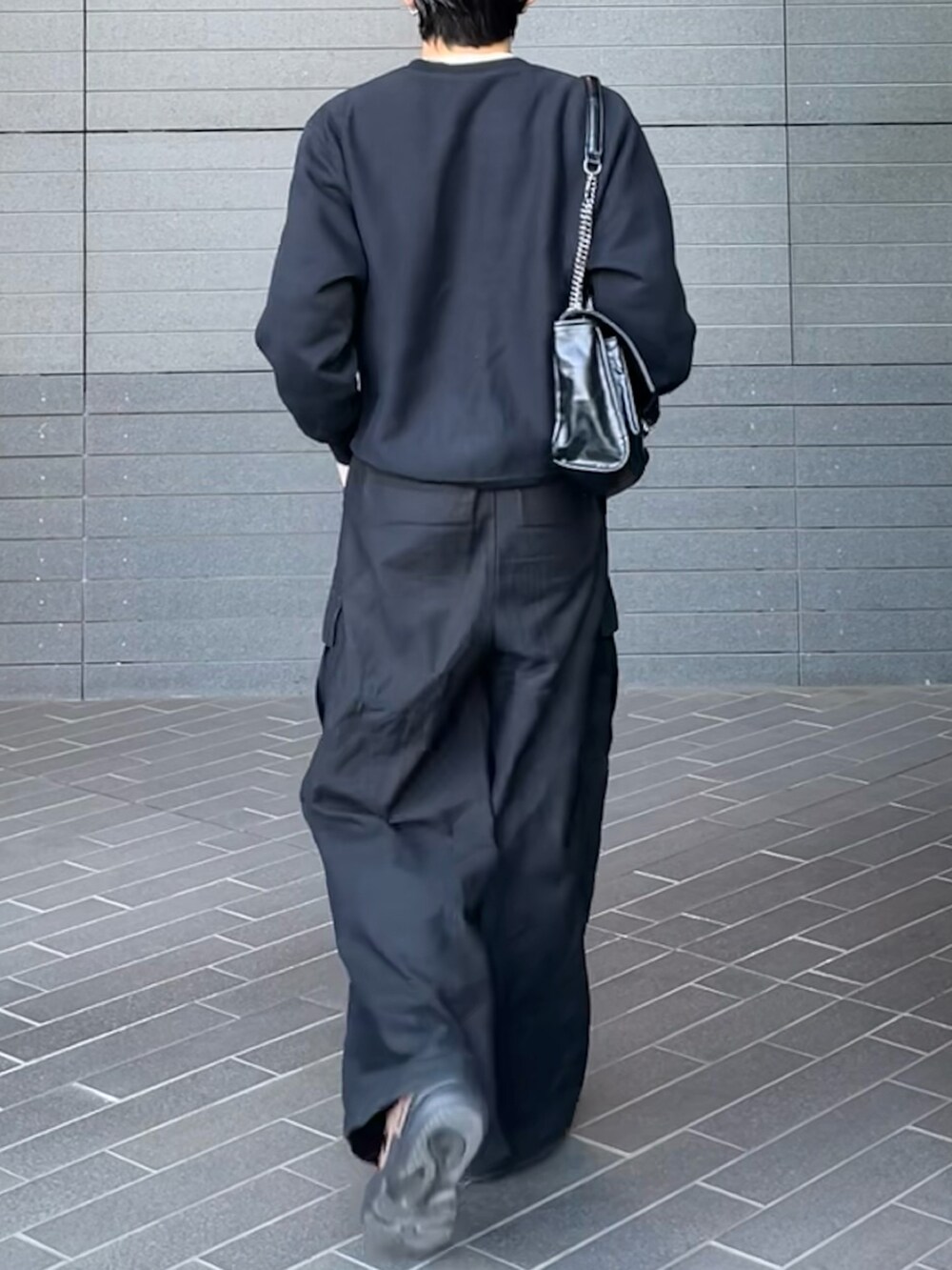 ブラック系のカーゴパンツ、グレー系のスウェット、ブラウン系のスニーカーを着用したメンズの春コーディネートの2枚目の写真