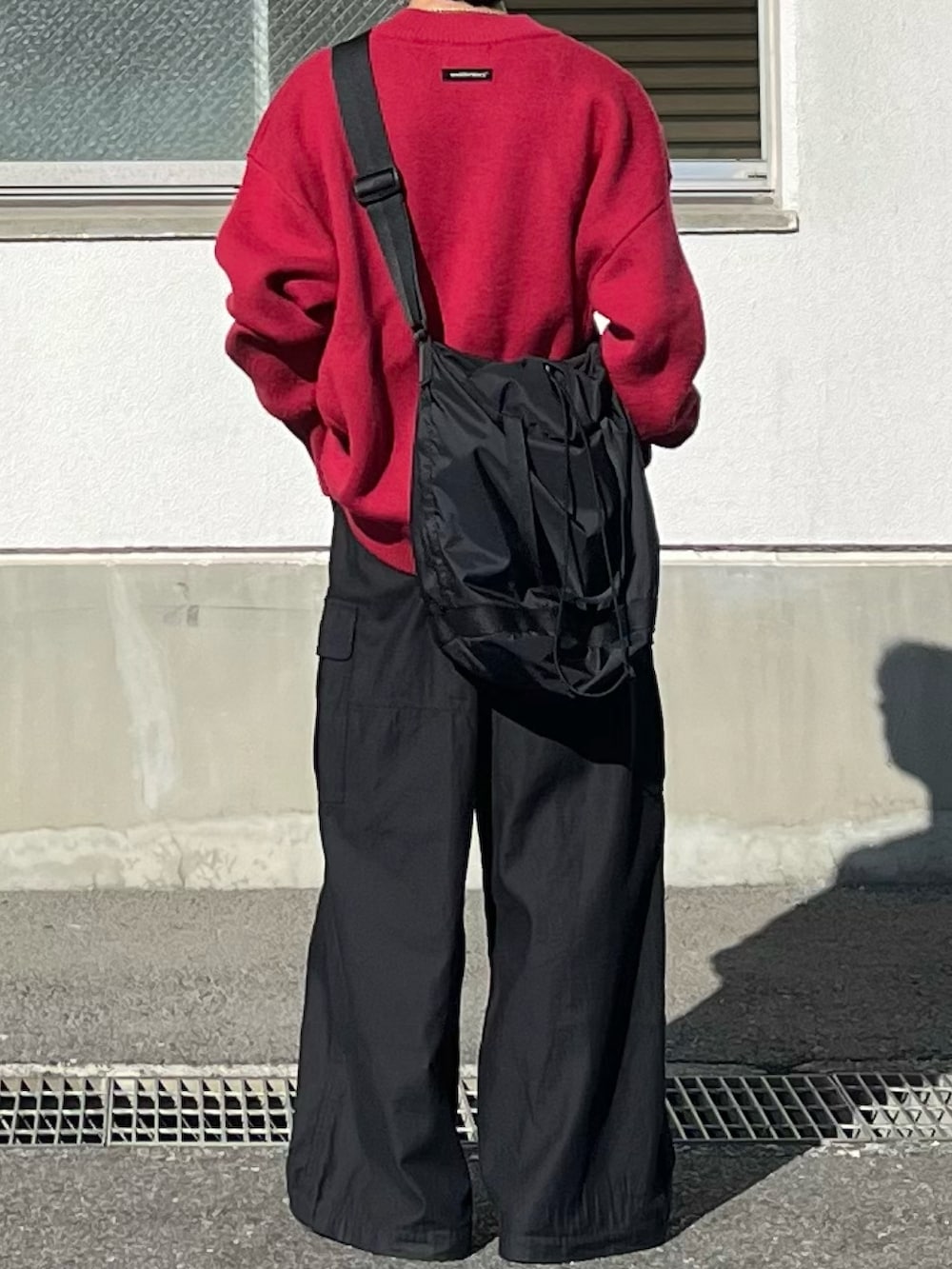 ブラック系のカーゴパンツ、レッド系のカーディガン/ボレロ、ブラウン系のローファーを着用したメンズの冬コーディネートの3枚目の写真