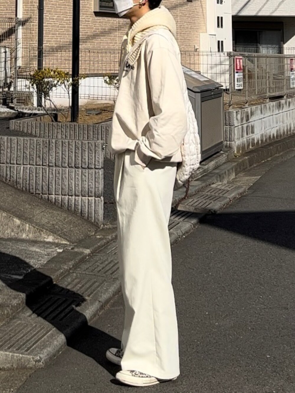 ホワイト系のスウェット、ホワイト系のスラックスを着用したメンズの春コーディネートの2枚目の写真