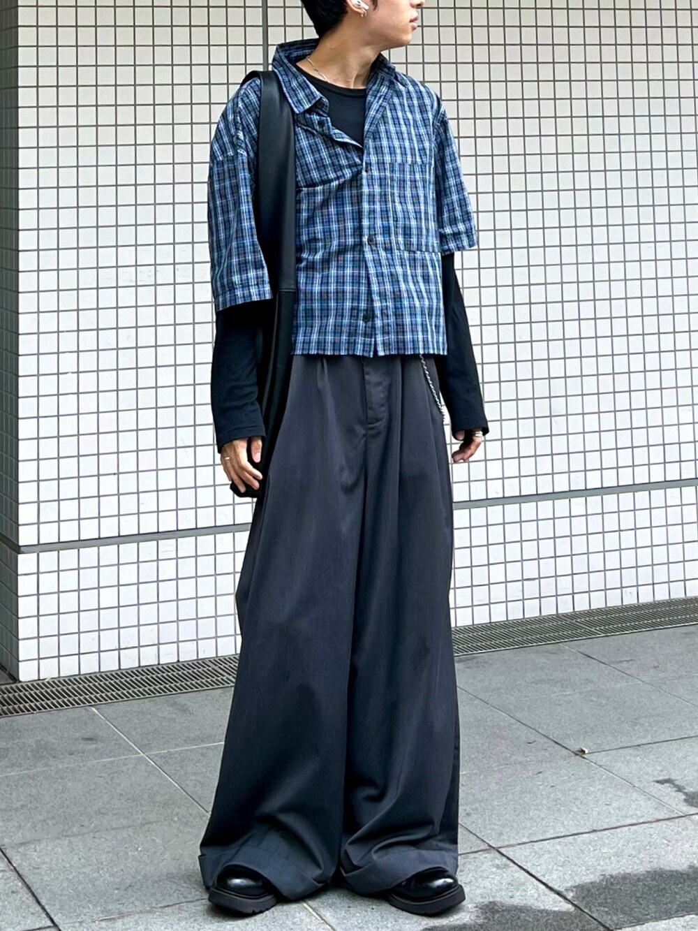 グレー系のスラックス、ブラック系のショルダーバッグ、シルバー系のウォレットチェーンを着用したメンズの秋コーディネートの2枚目の写真