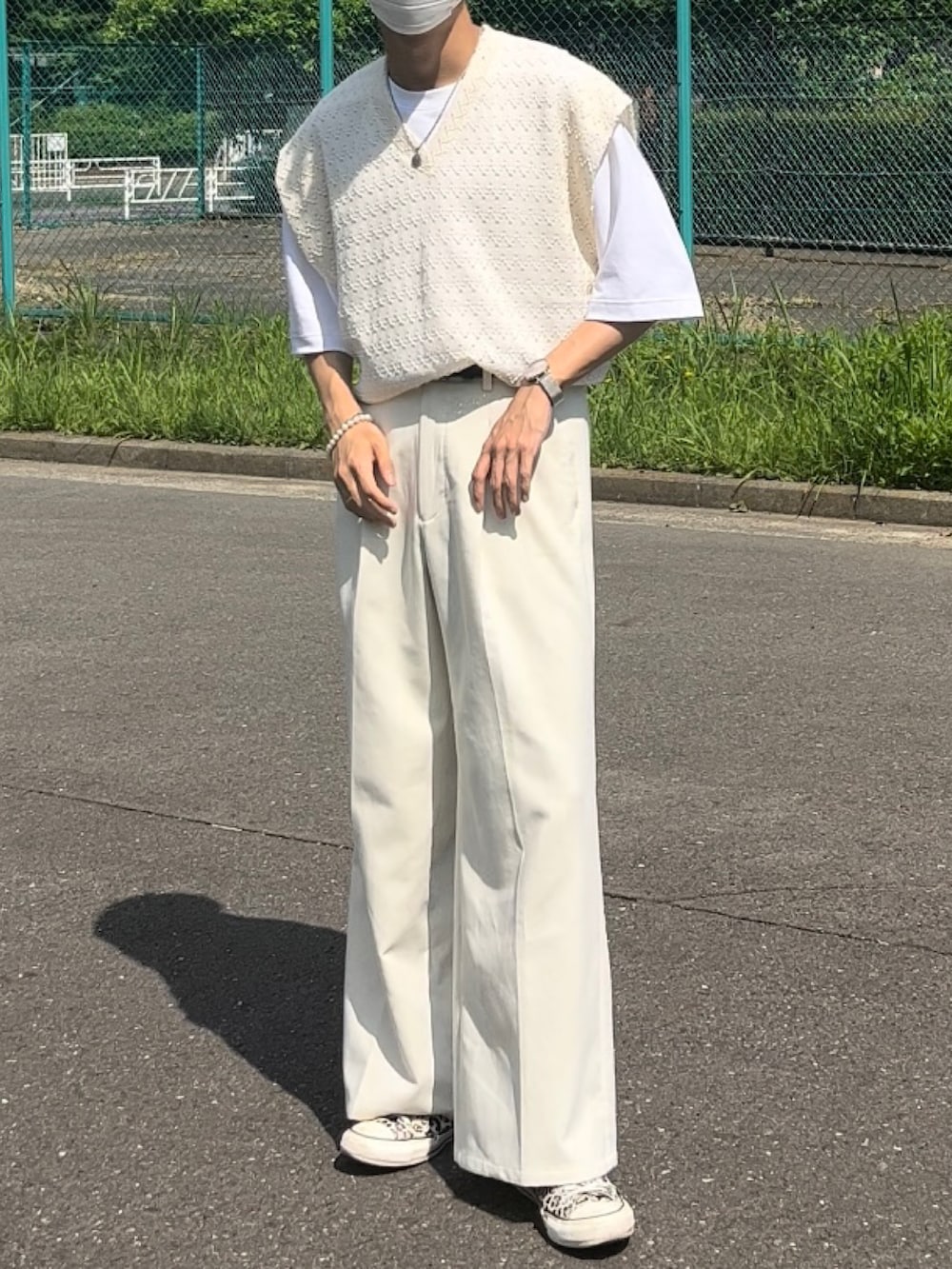 ホワイト系のベスト、ホワイト系のスラックス、ホワイト系のスニーカーを着用したメンズの夏コーディネートの2枚目の写真