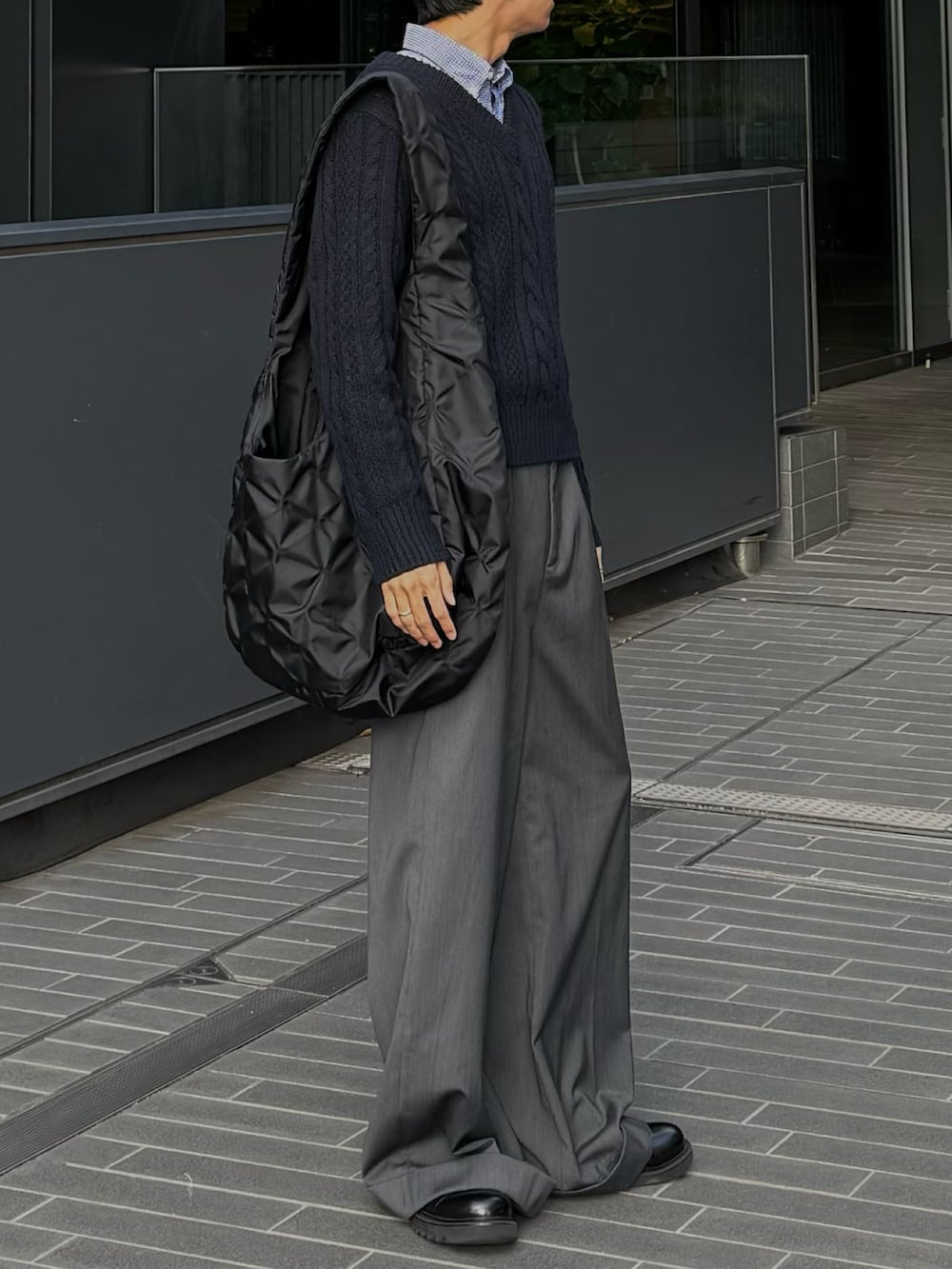 ブラック系のトートバッグ、グレー系のスラックスを着用したメンズの秋コーディネートの2枚目の写真