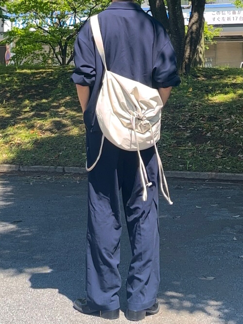 ベージュ系のショルダーバッグ、ブルー系のセットアップを着用したメンズの夏コーディネートの3枚目の写真