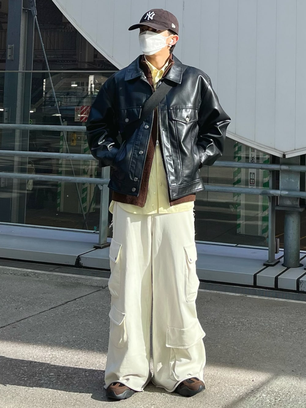 ホワイト系のスウェットパンツ、ブラウン系のニット/セーター、ブラック系のブルゾンを着用したメンズの冬コーディネートの2枚目の写真