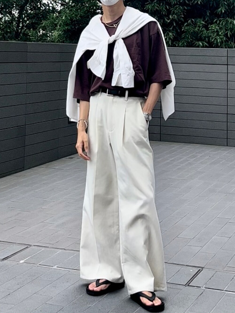 ブラウン系のTシャツ/カットソー、ホワイト系のスラックス、ブラック系のサンダルを着用したメンズの夏コーディネートの2枚目の写真