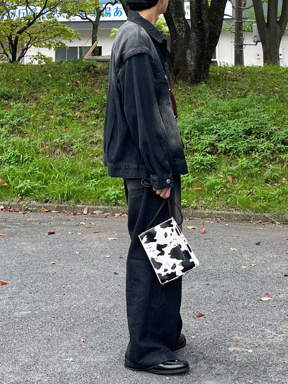 ベージュ系のショルダーバッグ、ブラック系のデニムパンツ、ブラック系のデニムジャケットを着用したメンズの秋コーディネートの2枚目の写真