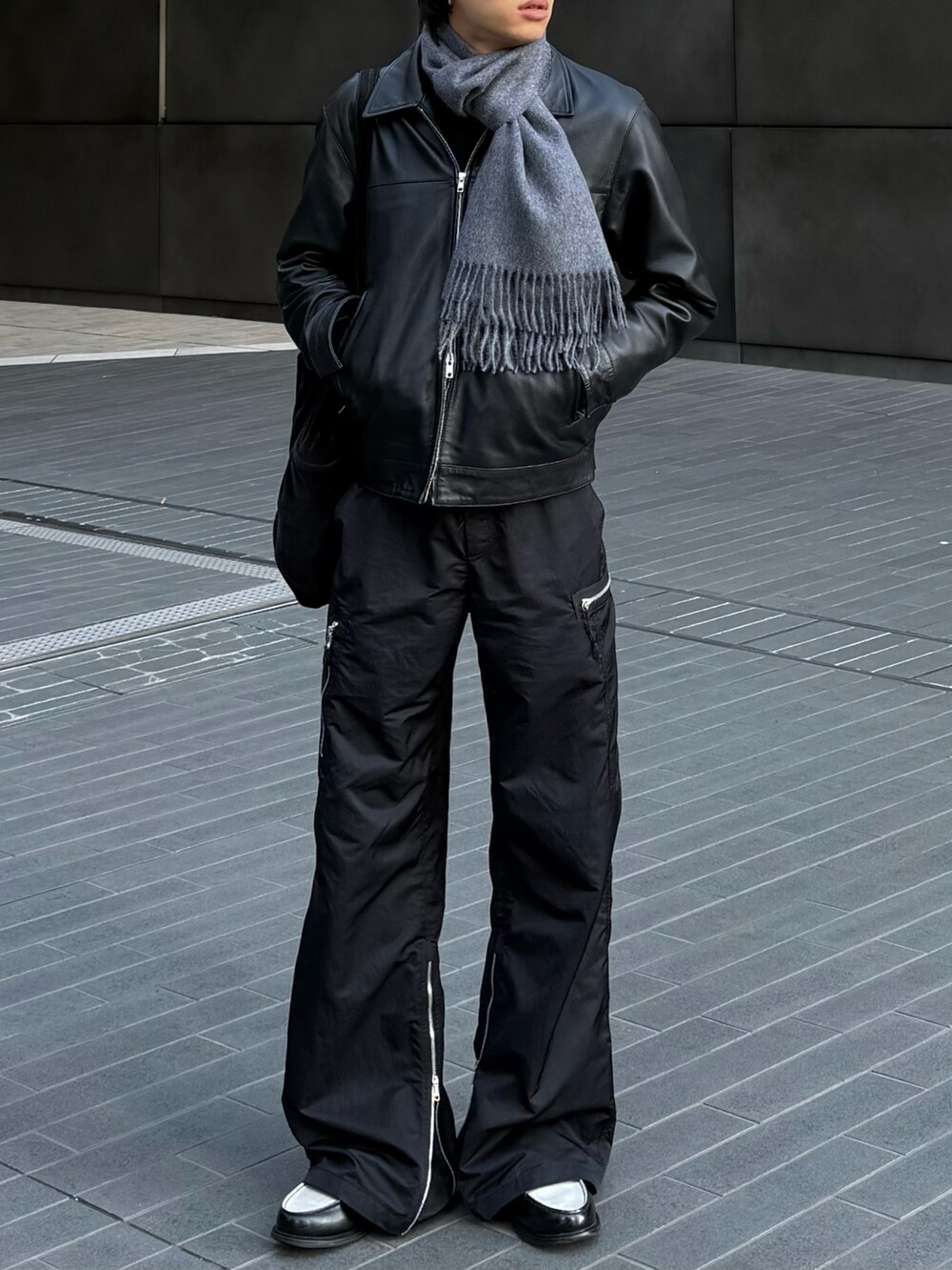 ブラック系のブルゾン、ブラック系のローファー、グレー系のマフラーを着用したメンズの冬コーディネートの2枚目の写真