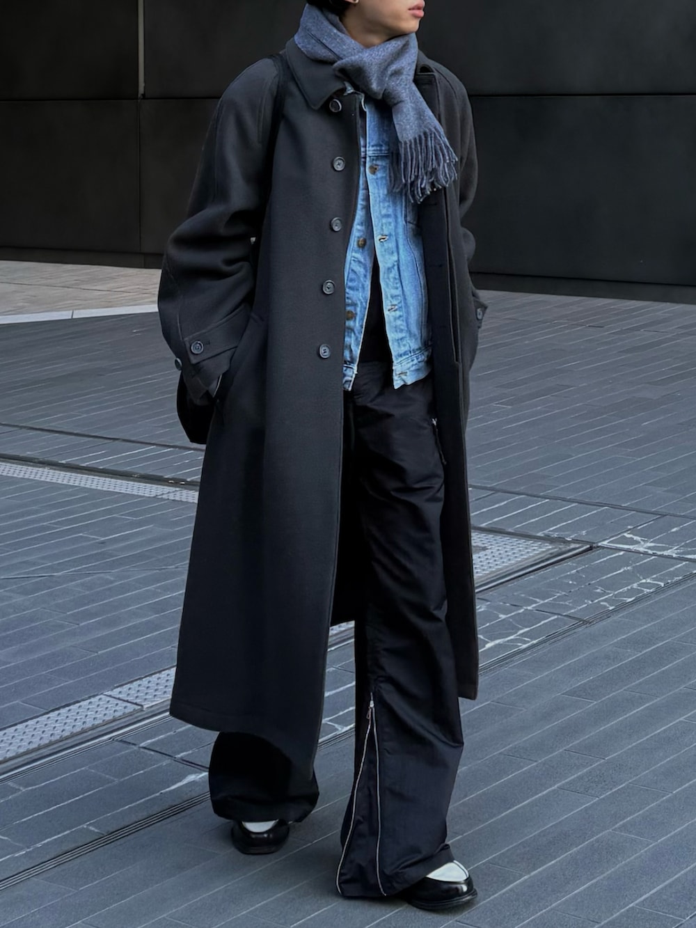 ブルー系のデニムジャケット、グレー系のステンカラーコート、ブラック系のローファーを着用したメンズの冬コーディネートの2枚目の写真