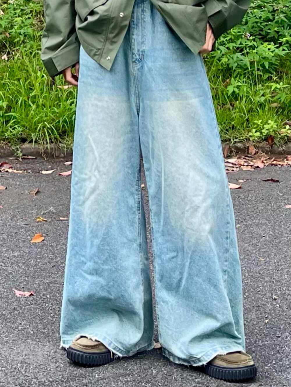 ブルー系のデニムパンツ、グリーン系のマウンテンパーカー、グリーン系のモカシン/デッキシューズを着用したメンズの秋コーディネートの4枚目の写真