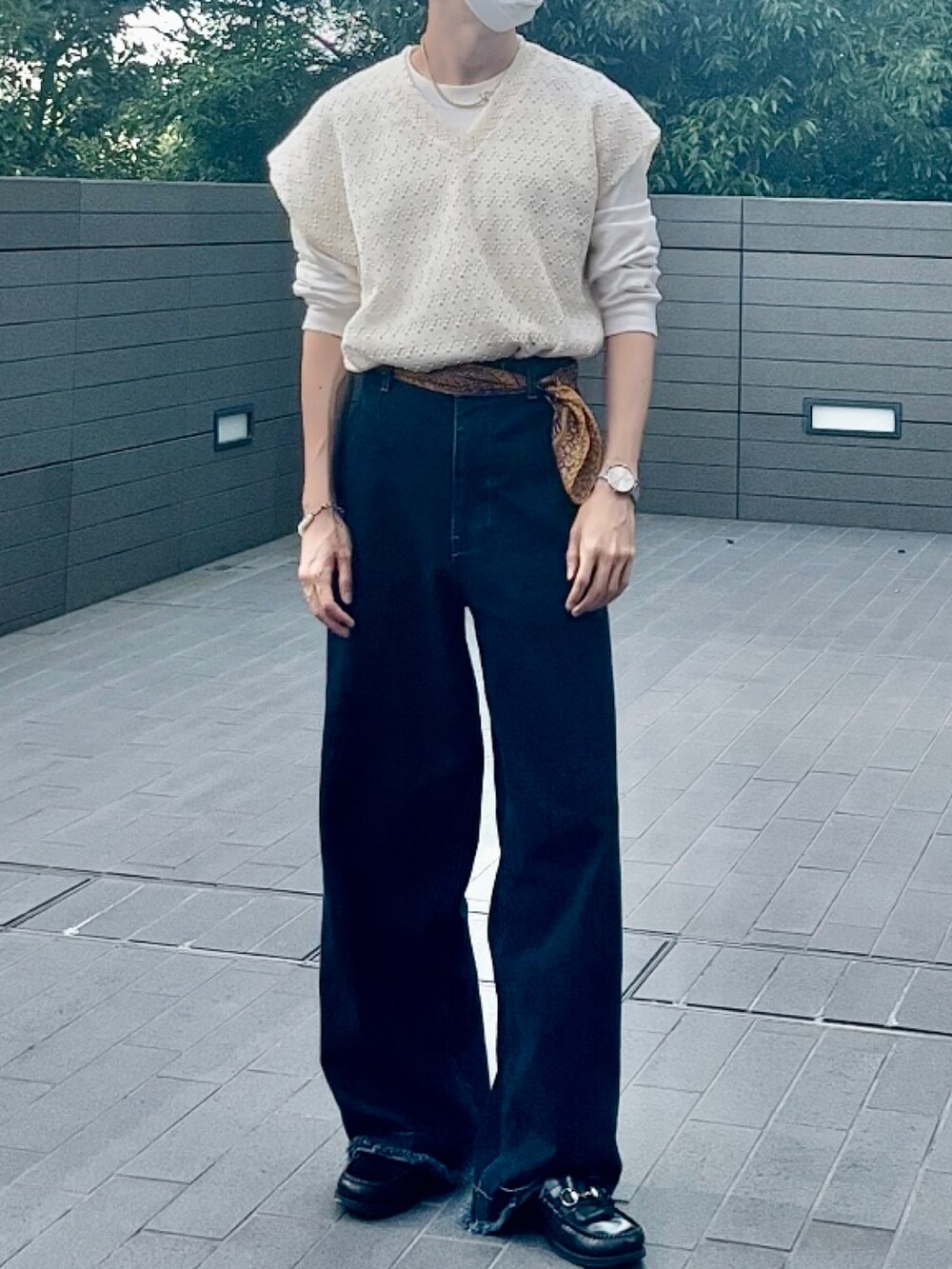 ホワイト系のベスト、ブルー系のデニムパンツを着用したメンズの夏コーディネートの2枚目の写真