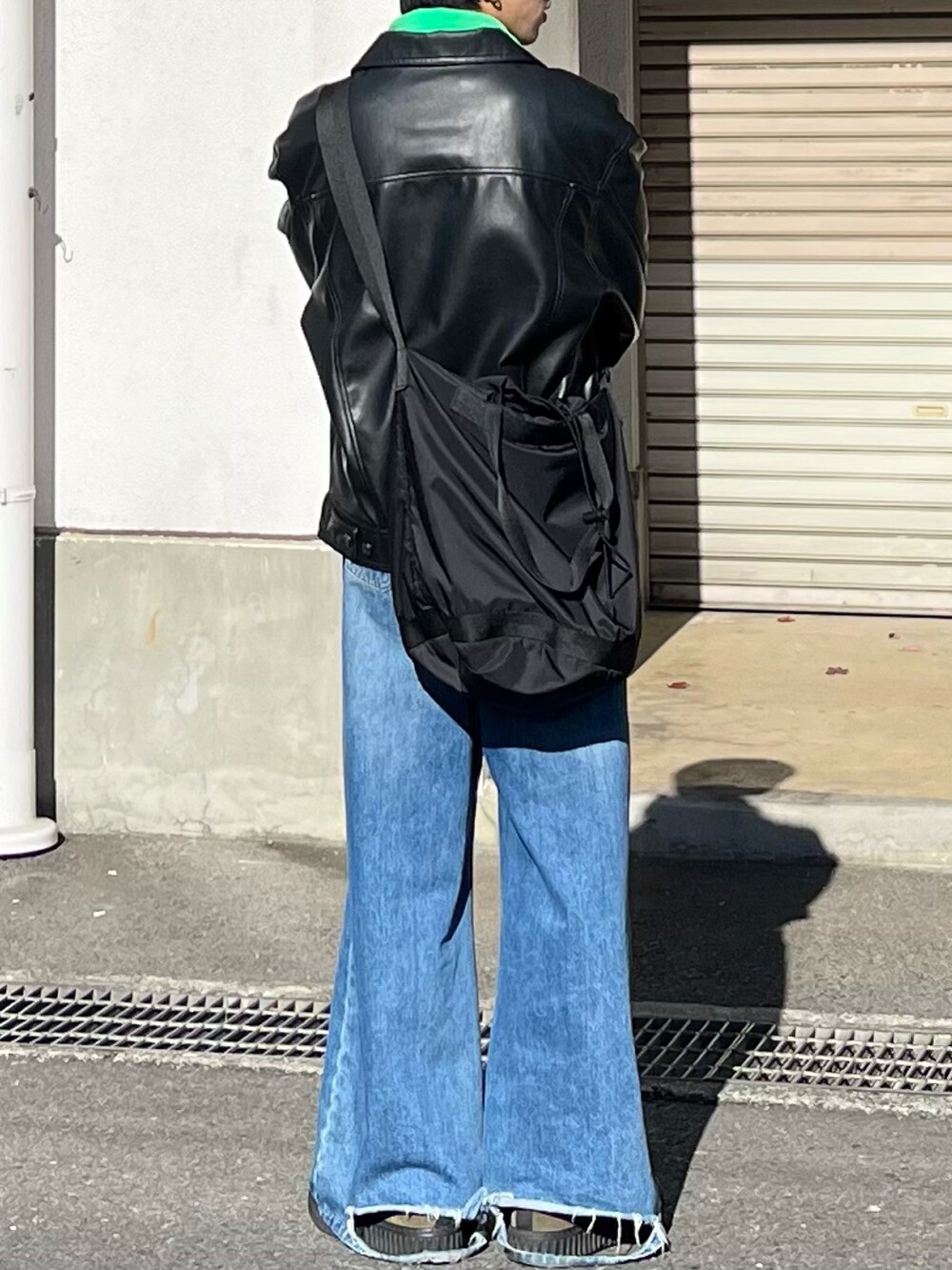 ブルー系のデニムパンツ、ブラック系のブルゾン、グリーン系のモカシン/デッキシューズを着用したメンズの秋コーディネートの3枚目の写真