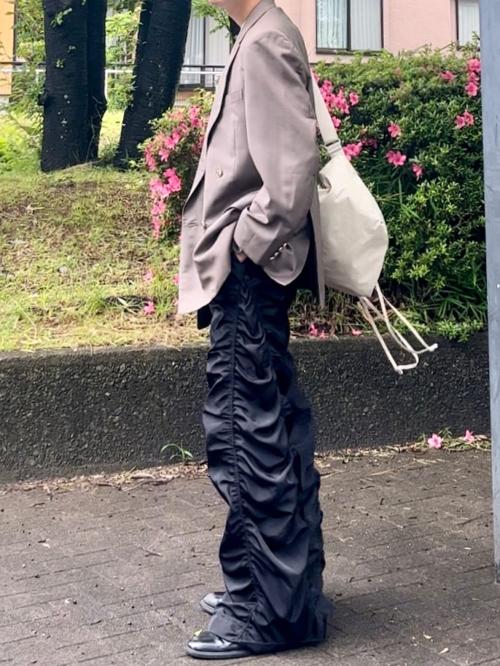 ブラック系のその他パンツ、ブラウン系のテーラードジャケット、ベージュ系のショルダーバッグを着用したメンズの夏コーディネートの2枚目の写真