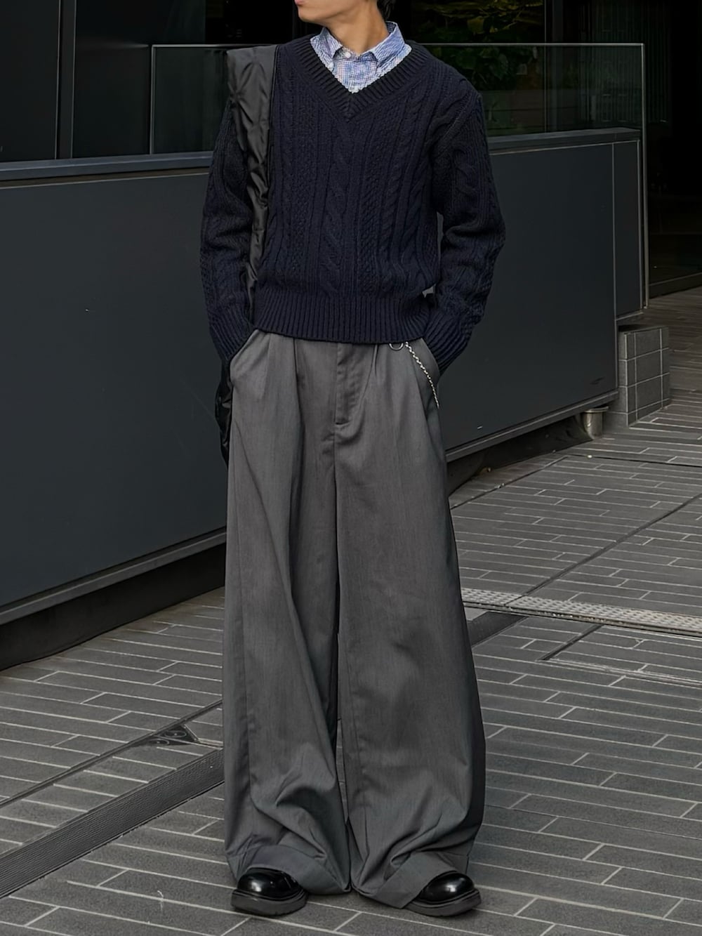 ブラック系のトートバッグ、グレー系のスラックスを着用したメンズの秋コーディネートの3枚目の写真