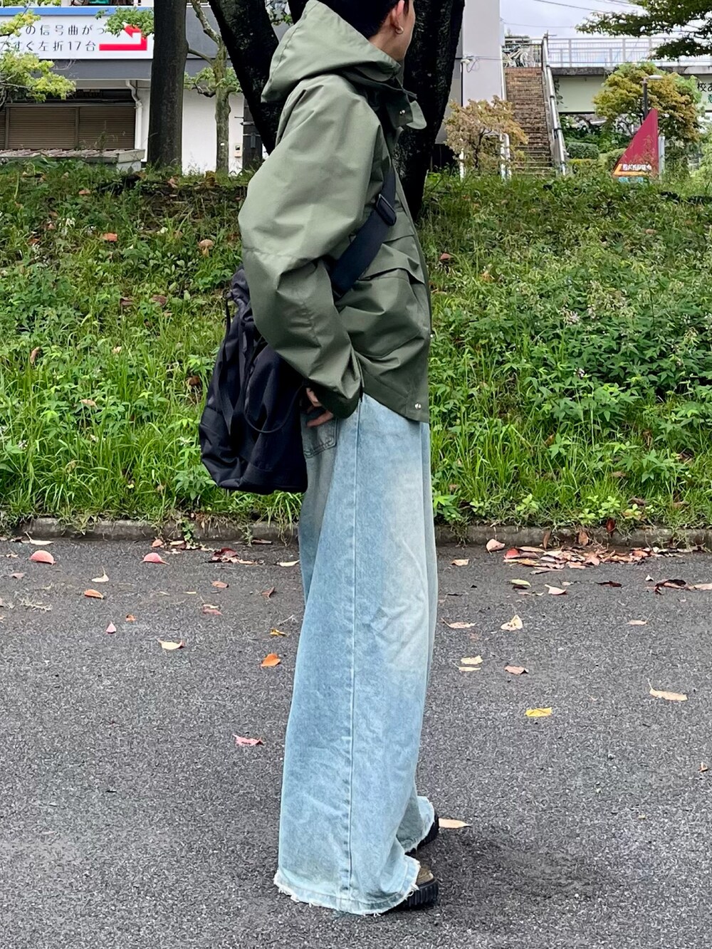 ブルー系のデニムパンツ、グリーン系のマウンテンパーカー、グリーン系のモカシン/デッキシューズを着用したメンズの秋コーディネートの2枚目の写真