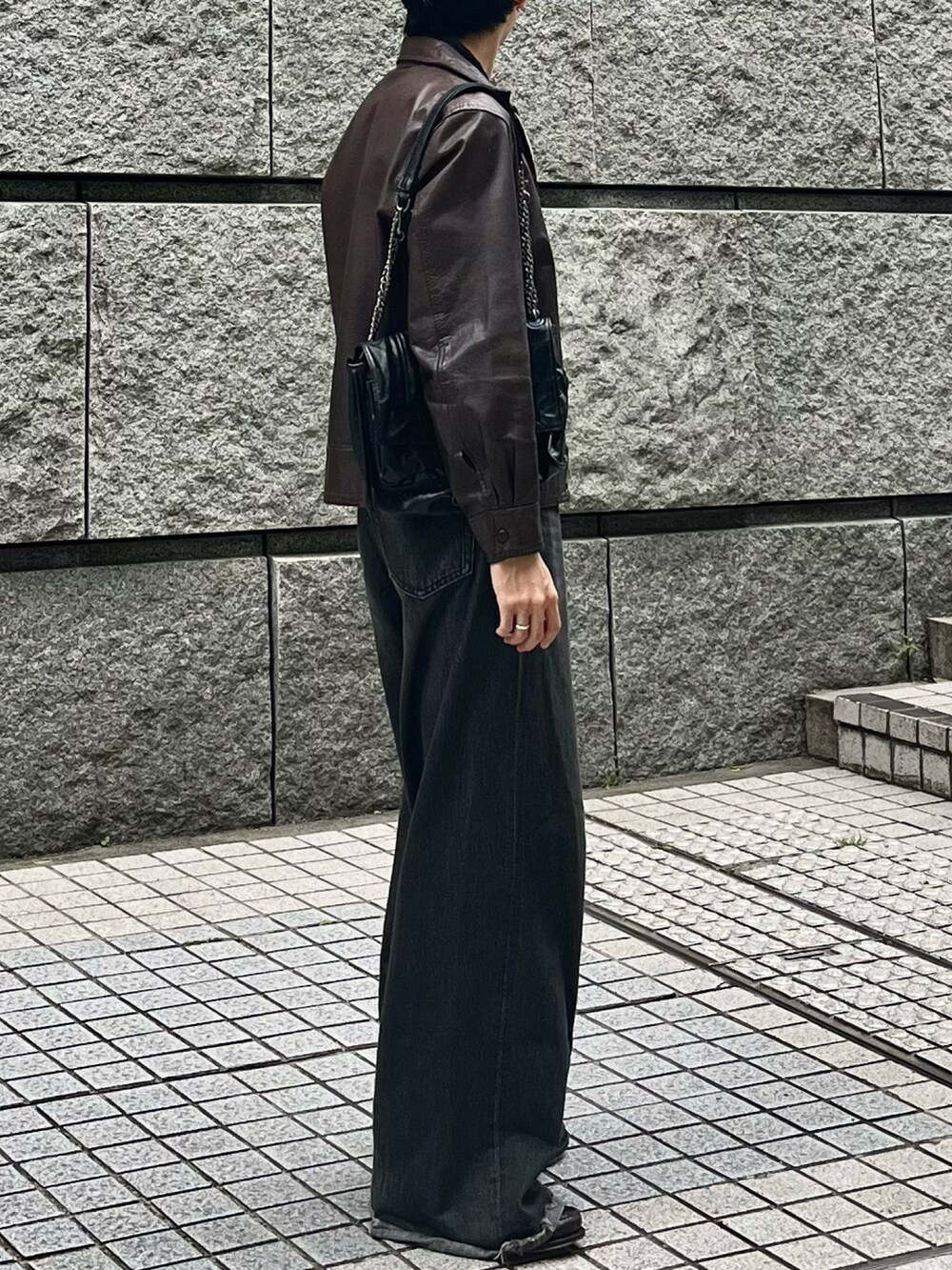 ブラック系のデニムパンツ、ブラウン系のローファーを着用したメンズの春コーディネートの2枚目の写真