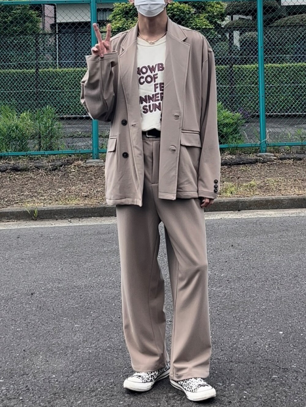 ベージュ系のセットアップ、ベージュ系のTシャツ/カットソー、ホワイト系のスニーカーを着用したメンズの春コーディネートの2枚目の写真