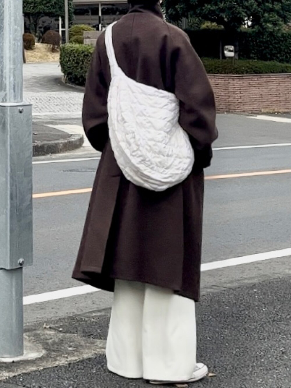 ブラウン系のその他アウター、ホワイト系のスラックス、ホワイト系のスニーカーを着用したメンズの冬コーディネートの2枚目の写真