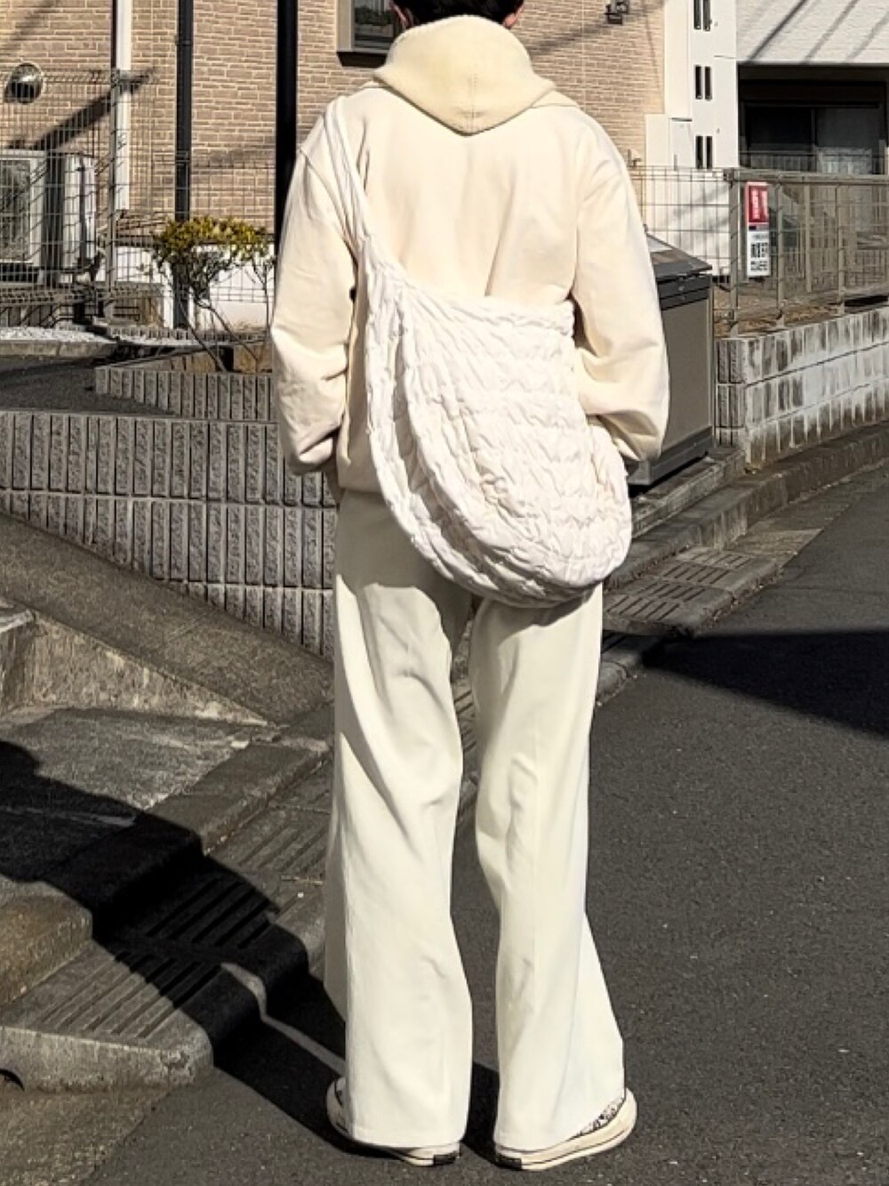 ホワイト系のスウェット、ホワイト系のスラックスを着用したメンズの春コーディネートの3枚目の写真