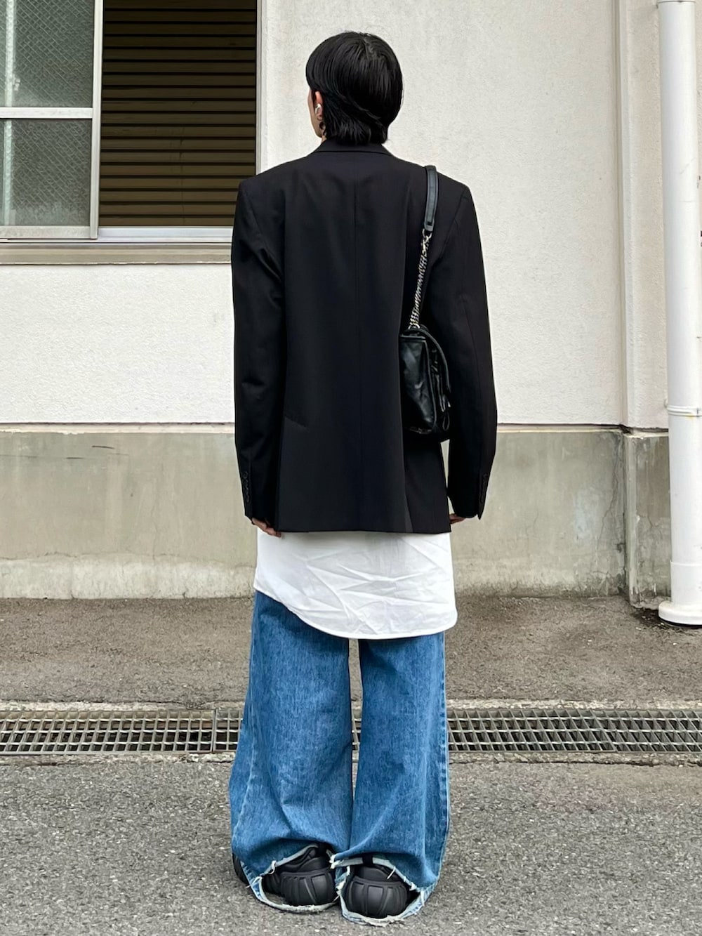 ブルー系のデニムパンツ、ホワイト系のシャツ/ブラウス、ブラック系のテーラードジャケットを着用したメンズの春コーディネートの2枚目の写真
