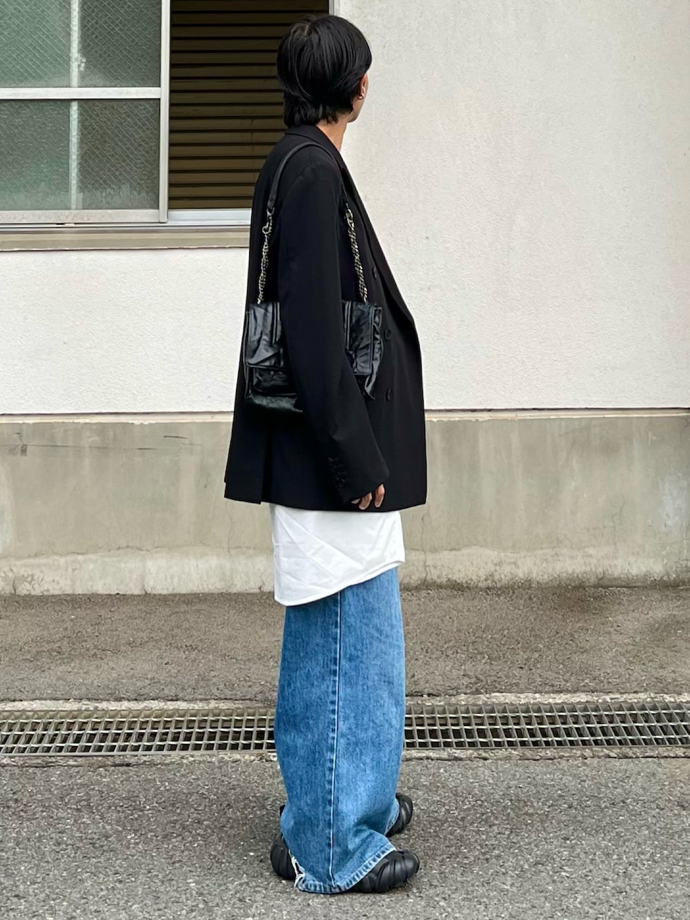 ブルー系のデニムパンツ、ホワイト系のシャツ/ブラウス、ブラック系のテーラードジャケットを着用したメンズの春コーディネートの3枚目の写真