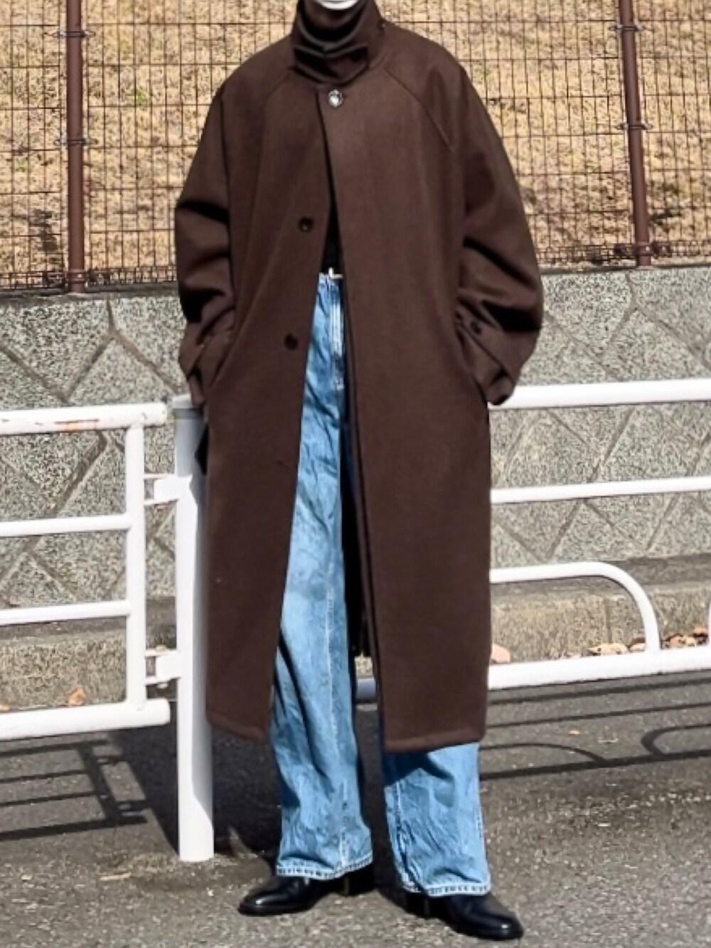 ブラック系のデニムパンツ、ブラウン系のその他アウター、ブラック系のニット/セーターを着用したメンズの冬コーディネートの3枚目の写真