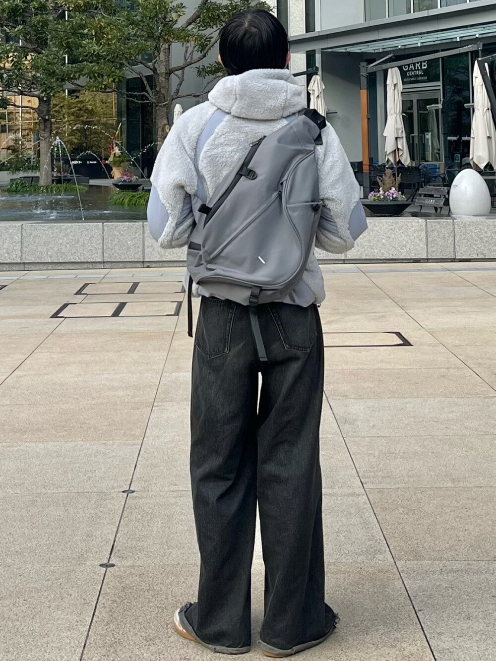 ブラック系のデニムパンツ、グレー系のその他アウター、グレー系のショルダーバッグを着用したメンズの冬コーディネートの4枚目の写真