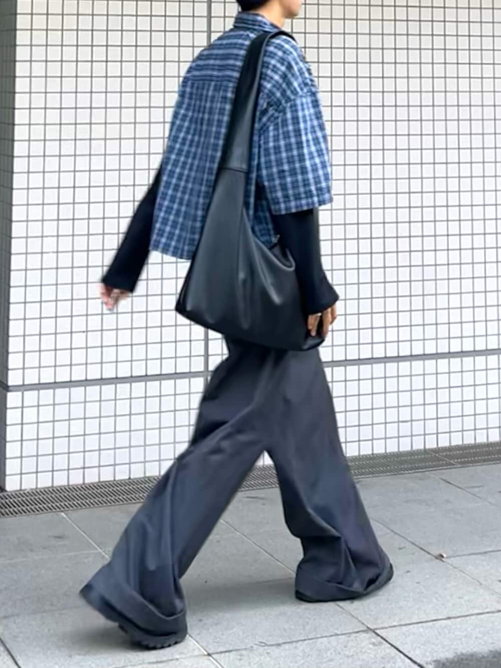 グレー系のスラックス、ブラック系のショルダーバッグ、シルバー系のウォレットチェーンを着用したメンズの秋コーディネートの3枚目の写真