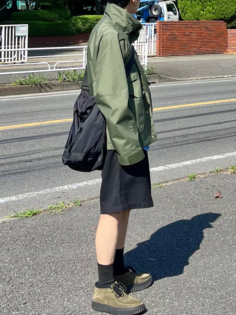 ブラック系のその他パンツ、グリーン系のマウンテンパーカー、ブルー系のシャツ/ブラウスを着用したメンズの秋コーディネートの2枚目の写真