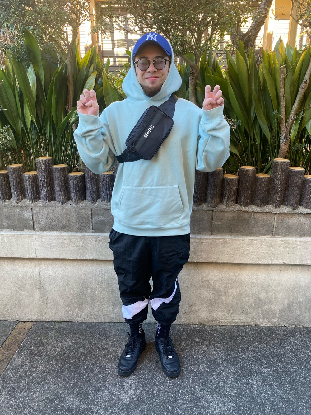 ブルー系のパーカー、ブラック系のショルダーバッグ、ブラック系のその他パンツを着用したメンズの冬コーディネートの2枚目の写真