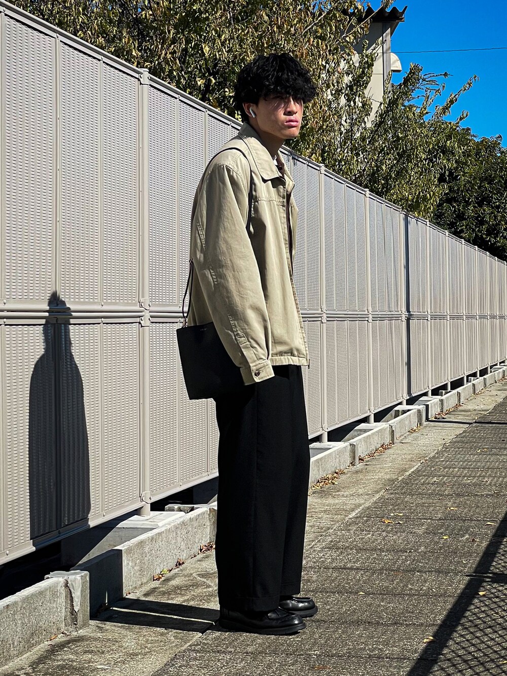 ブラウン系のカーディガン/ボレロ、ブラック系のスラックス、ブラック系のドレスシューズを着用したメンズの秋コーディネートの2枚目の写真