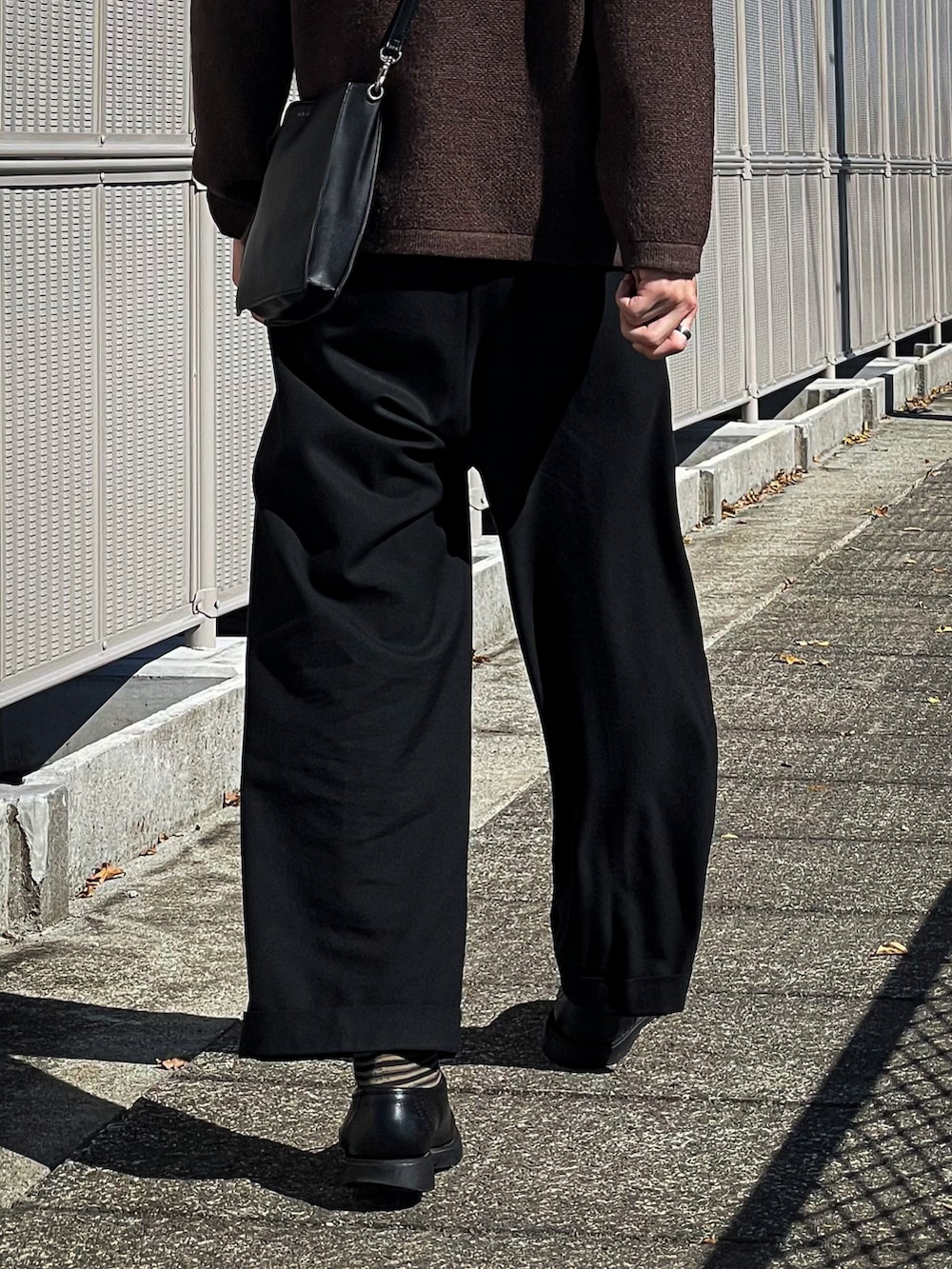 ブラウン系のカーディガン/ボレロ、グレー系のTシャツ/カットソー、ブラック系のスラックスを着用したメンズの秋コーディネートの3枚目の写真