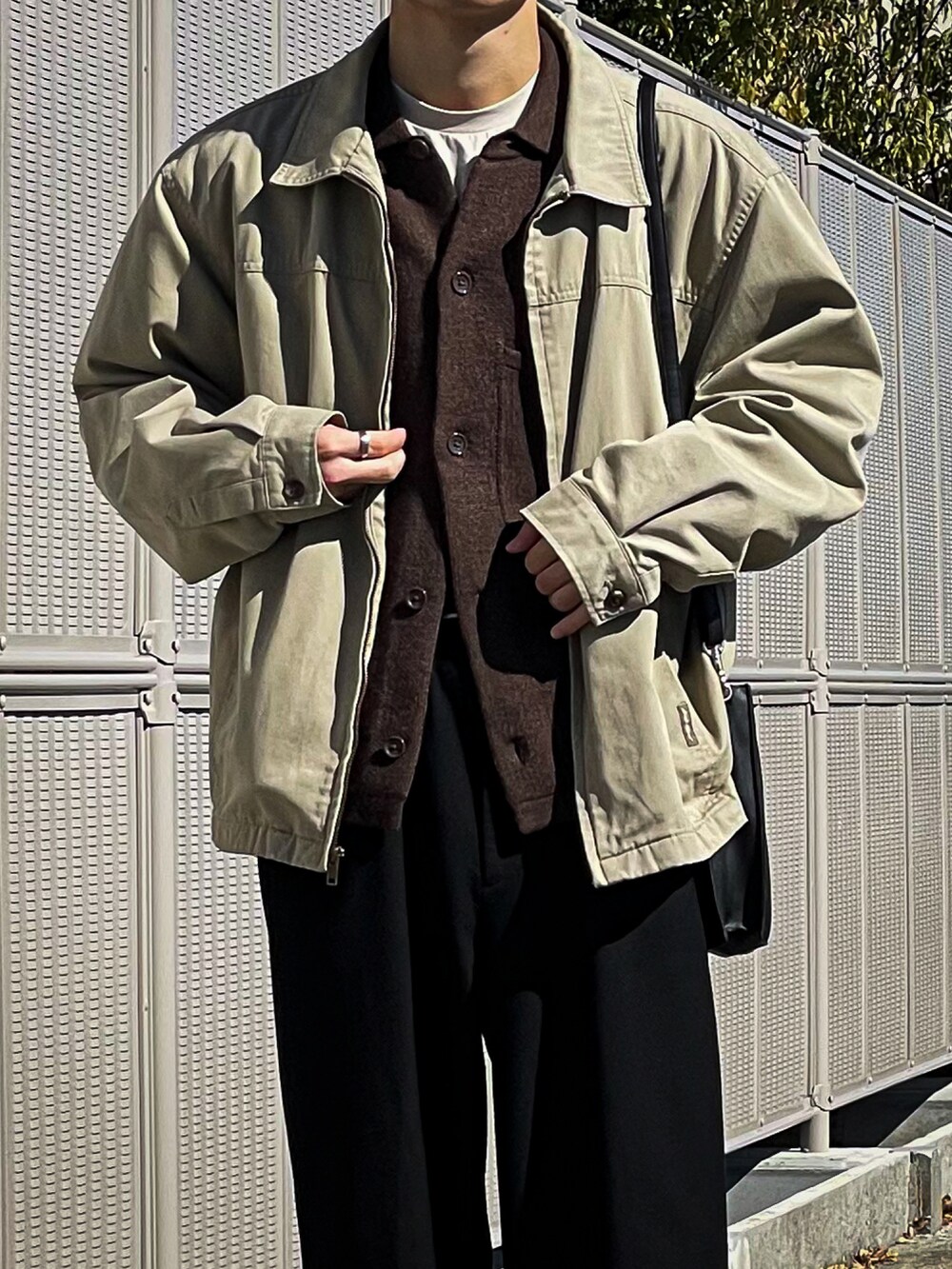 ブラウン系のカーディガン/ボレロ、ブラック系のスラックス、ブラック系のドレスシューズを着用したメンズの秋コーディネートの3枚目の写真