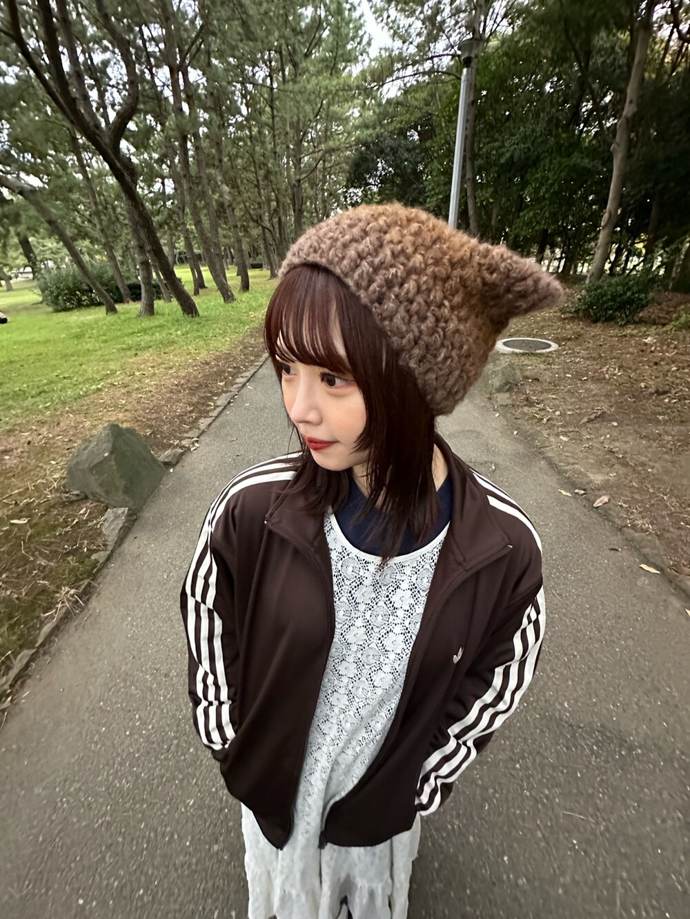 ブラウン系のジャージ、ホワイト系のワンピースを着用したレディースの冬コーディネートの2枚目の写真