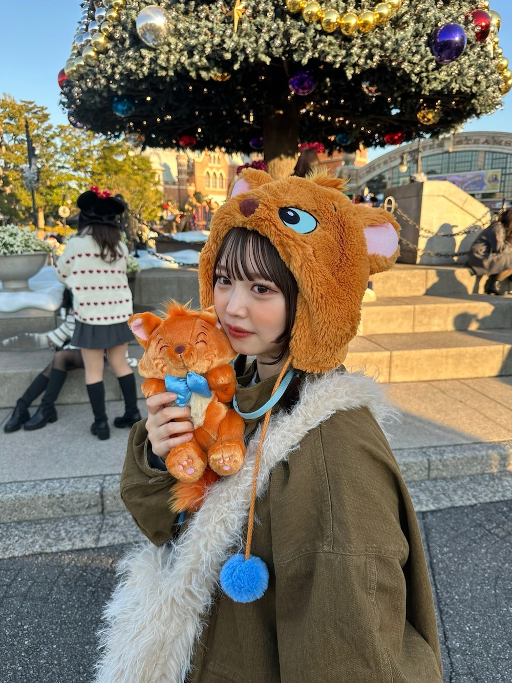 ブラウン系のモッズコート、ホワイト系のスニーカー、ホワイト系のショルダーバッグを着用したレディースの冬コーディネートの2枚目の写真