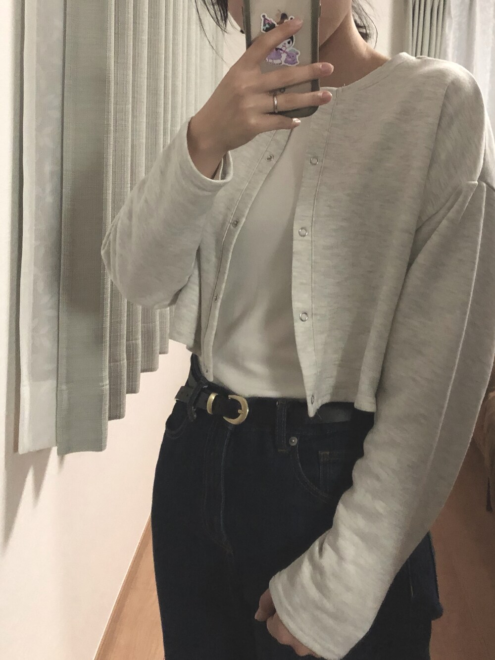 ブルー系のデニムパンツ、グレー系のカーディガン/ボレロ、ホワイト系のTシャツ/カットソーを着用したレディースの冬コーディネートの2枚目の写真