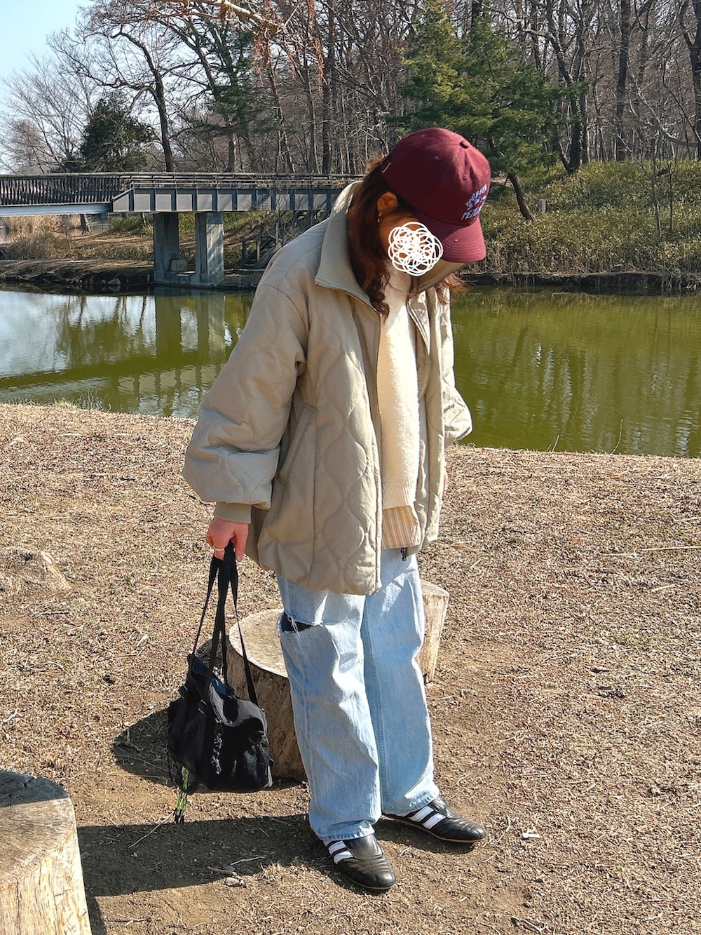 ベージュ系のニット/セーター、グリーン系のブルゾン、ブラック系のスニーカーを着用したレディースの冬コーディネートの2枚目の写真