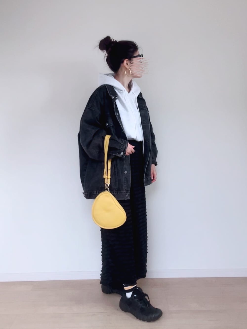 ブラック系のデニムジャケット、グレー系のパーカー、ブラック系のスカートを着用したレディースの秋コーディネートの2枚目の写真