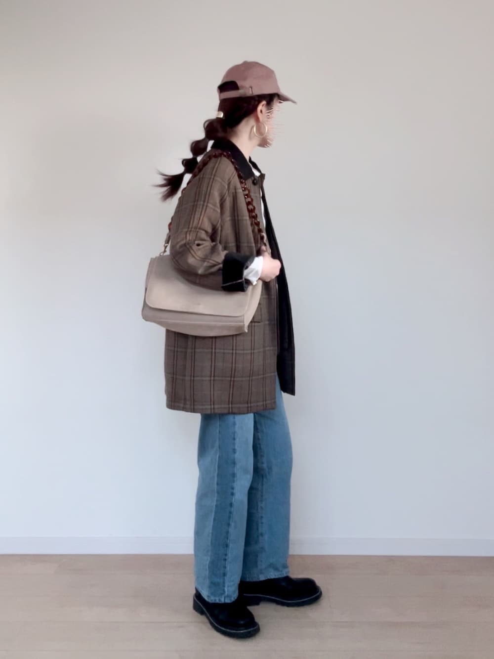 ブラウン系のブルゾン、ホワイト系のTシャツ/カットソー、ブルー系のデニムパンツを着用したレディースの秋コーディネートの2枚目の写真