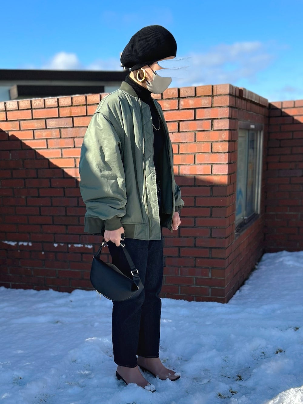 グリーン系のMA-1、ピンク系のブーツ、ブラック系のハンチング/ベレー帽を着用したレディースの冬コーディネートの2枚目の写真