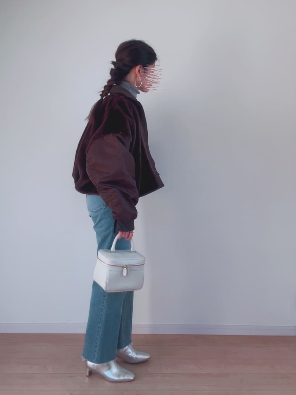 ブラウン系のミリタリージャケット、グレー系のニット/セーター、ブルー系のデニムパンツを着用したレディースの冬コーディネートの2枚目の写真