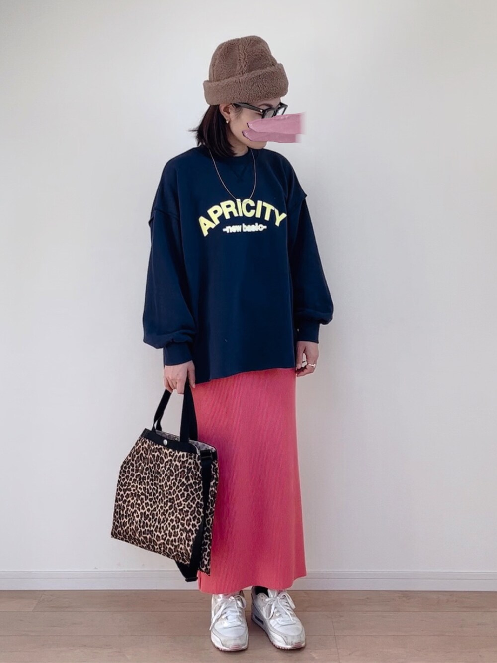 ブルー系のスウェット、ピンク系のスカート、ホワイト系のスニーカーを着用したレディースの秋コーディネートの2枚目の写真