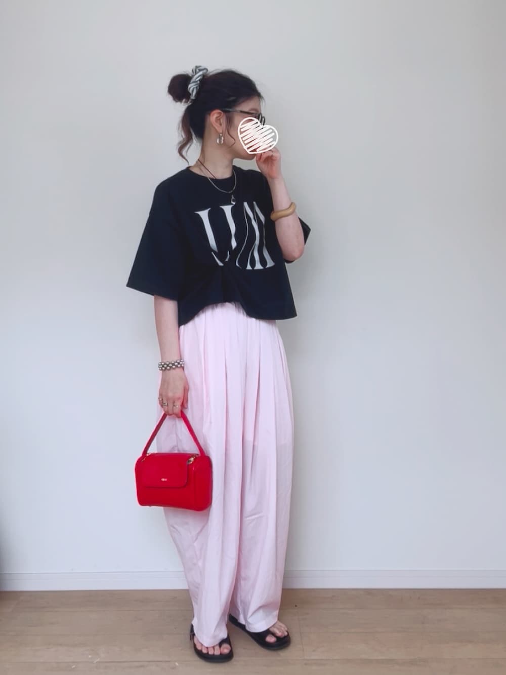ブラック系のTシャツ/カットソー、レッド系のハンドバッグ、ブラック系のサンダルを着用したレディースの夏コーディネートの2枚目の写真