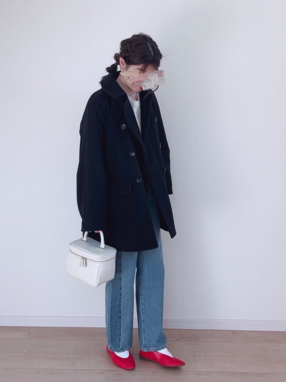 ブルー系のピーコート、ホワイト系のニット/セーター、ブルー系のデニムパンツを着用したレディースの冬コーディネートの2枚目の写真