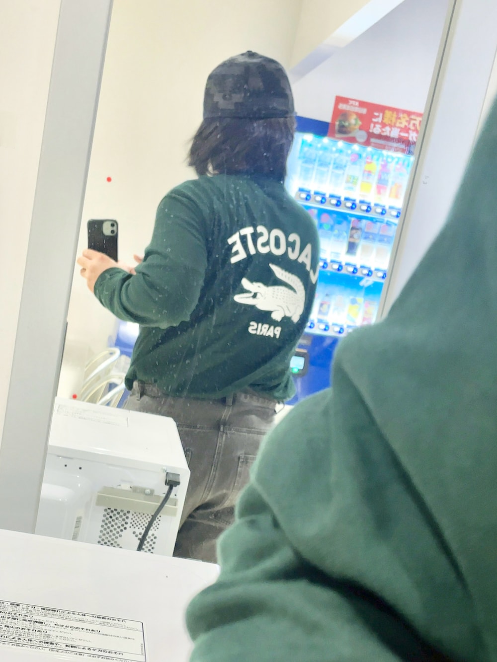 ブラック系のデニムパンツ、グリーン系のTシャツ/カットソー、ブラック系のトートバッグを着用したメンズの秋コーディネートの2枚目の写真