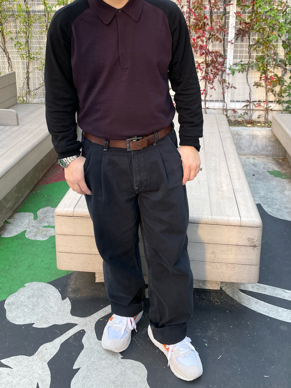 パープル系のニット/セーター、ブラック系のデニムパンツ、オレンジ系のスニーカーを着用したメンズの秋コーディネートの2枚目の写真