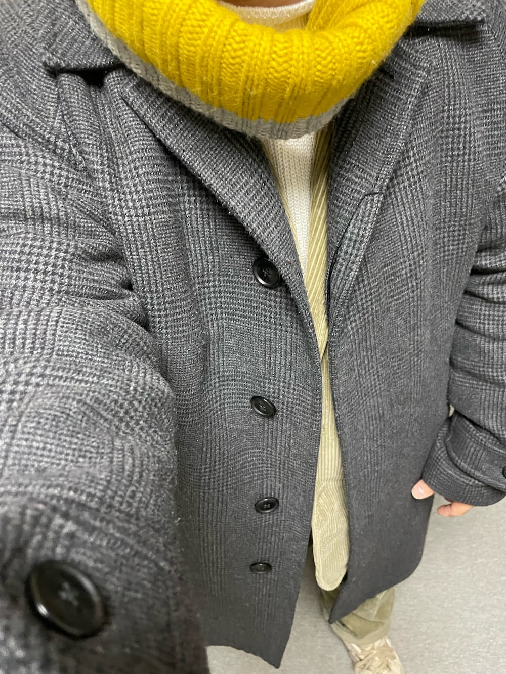 ホワイト系のニット/セーター、ベージュ系のテーラードジャケット、グレー系のステンカラーコートを着用したメンズの冬コーディネートの2枚目の写真