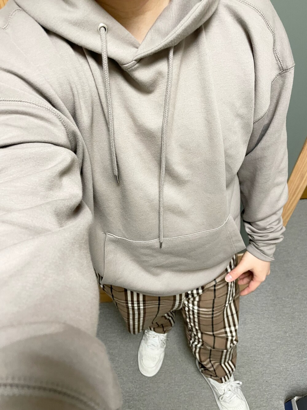 ベージュ系のパーカー、ブラウン系のその他パンツ、ホワイト系のスニーカーを着用したメンズの春コーディネートの2枚目の写真