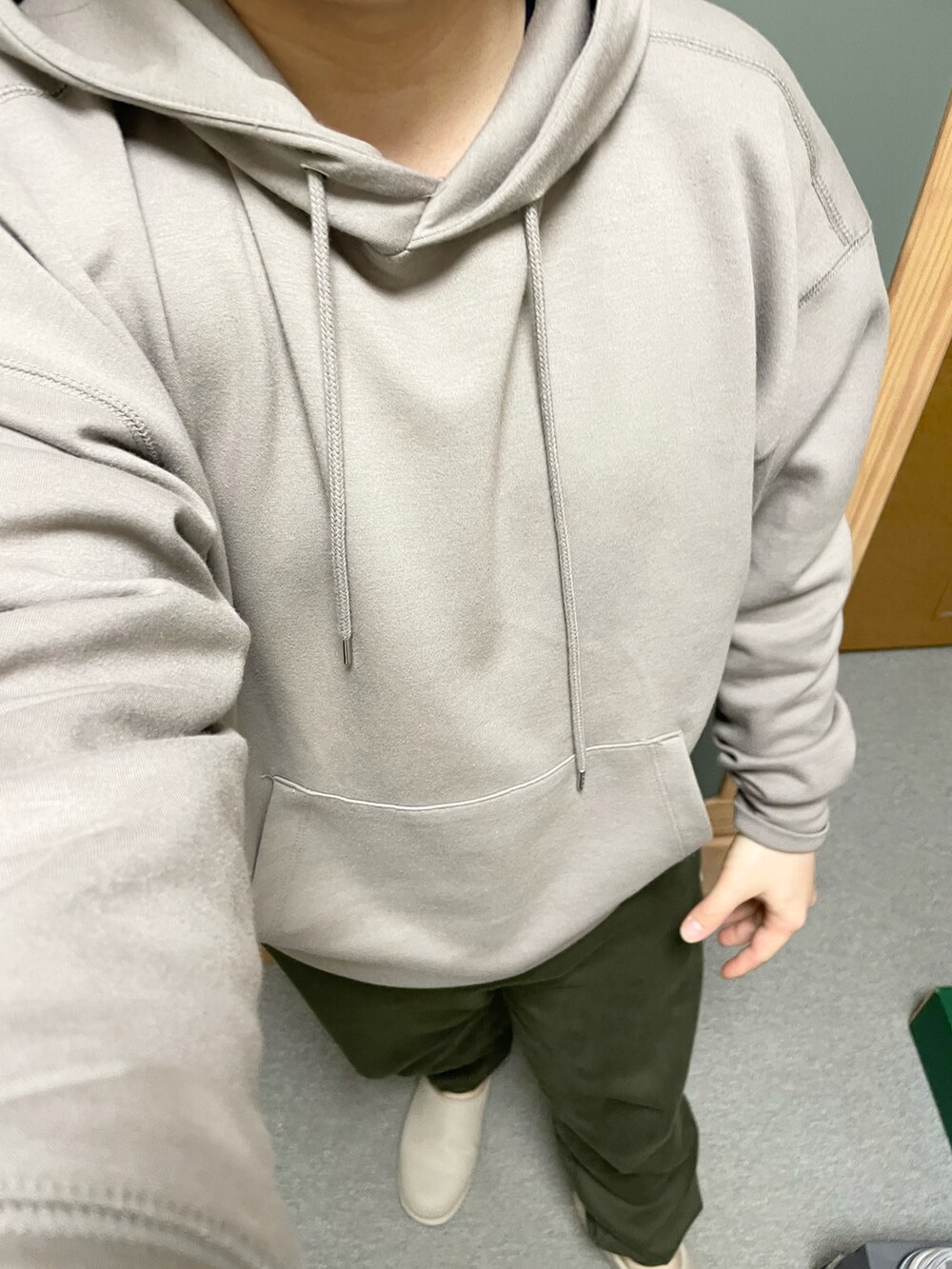 ベージュ系のパーカー、グリーン系のその他パンツ、ベージュ系のスニーカーを着用したメンズの春コーディネートの2枚目の写真